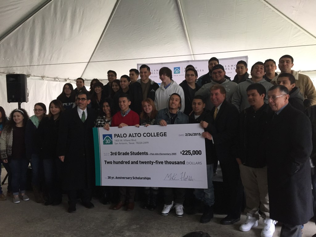 Photo of Palo Alto College President Mike Flores (left) and Alamo Colleges Trustee Joe Alderete (right) hold a scholarship check while surrounded by South San High School students. 