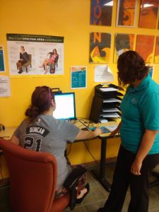 Photo of Veronica Sandoval, peer adviser, helps a student use PAC Connect in the Career Service Center. Photo by Deven Malone.