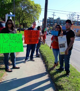 Students hold protest signs during the Alamo Colleges District Board Meeting. Photo by Juliet Mendoza