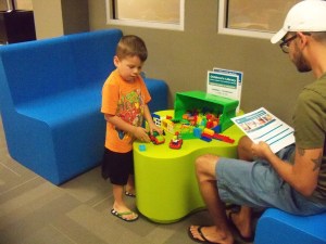 Photo of father and son play during Lego Night. 