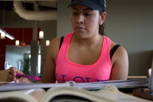 Photo of Reyna Ochoa multitasks with multiple assignments in the Ozuna Library 