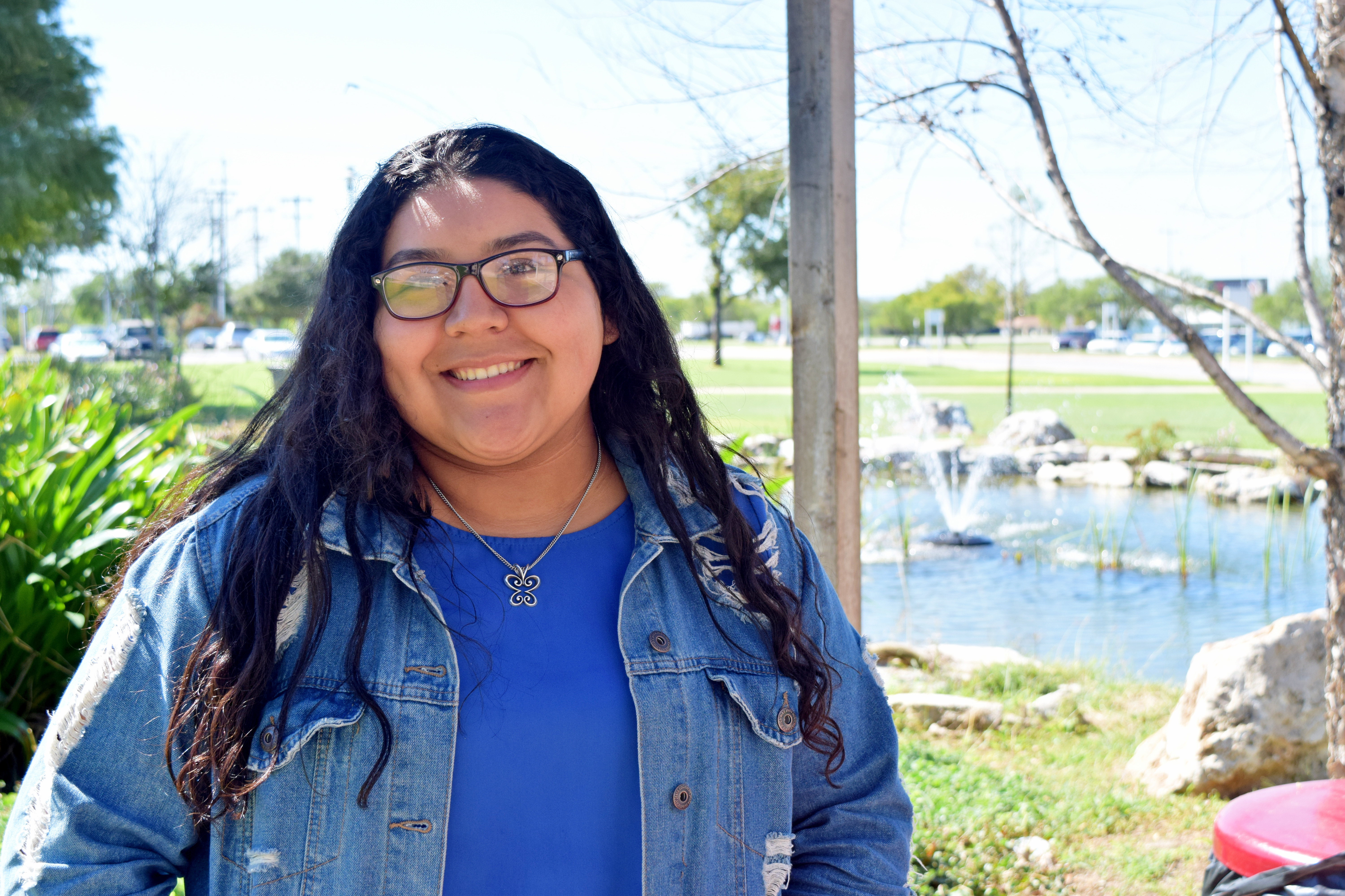 Emily Rodriguez, Early College High School Student at STEM High School, sits with her friends at the duck pond while they study and finish homework.