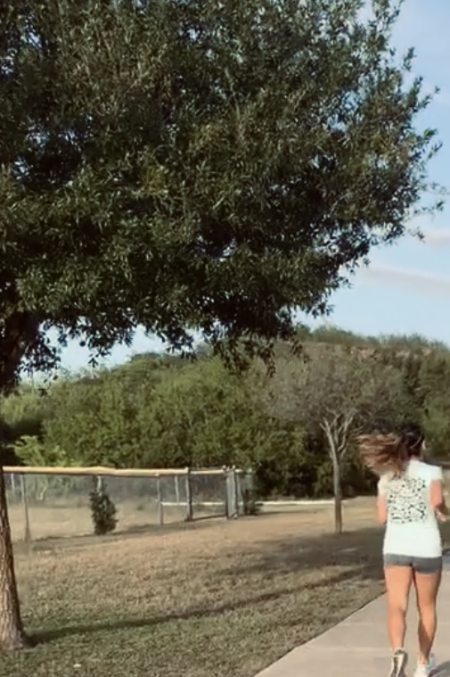 Photo of female jogging through a park.